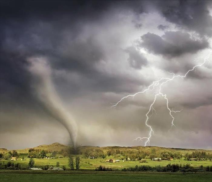 Tornado and lightning bolts striking field