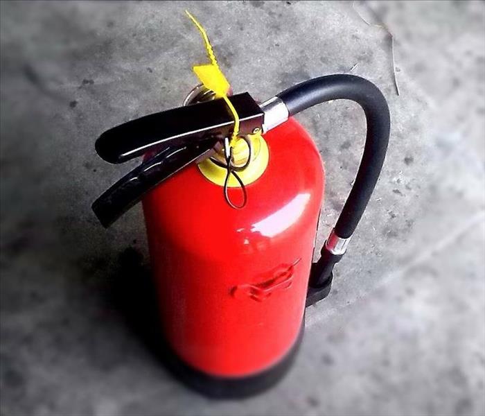 Red fire extinguisher on concrete floor 